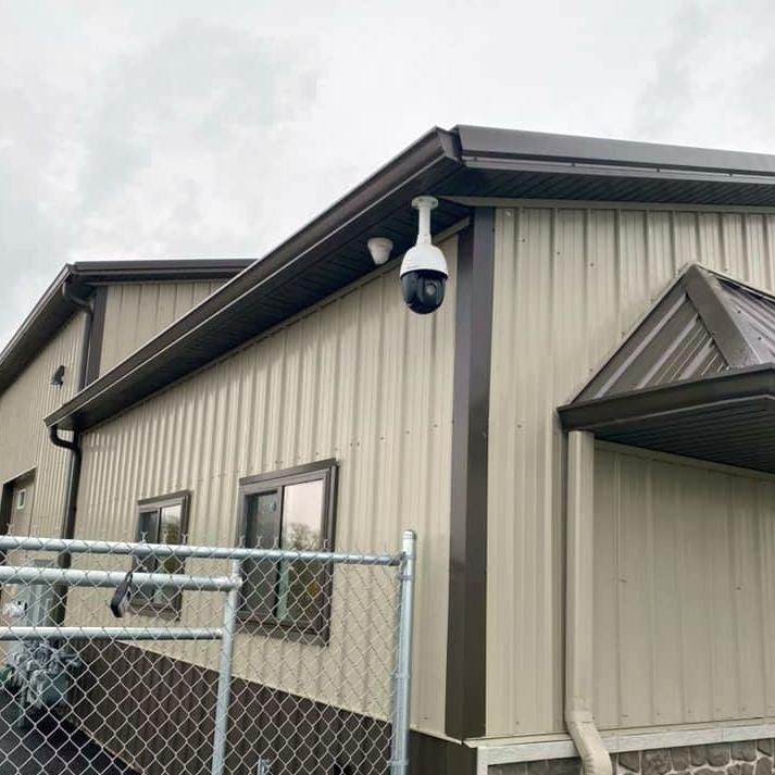 Exterior corner of brown and tan building featuring security camera installation